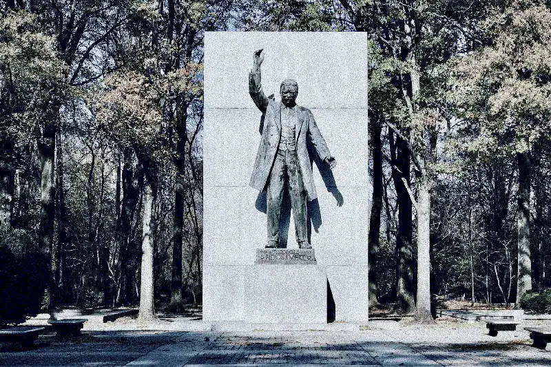 Stone figure in the park with raised arm