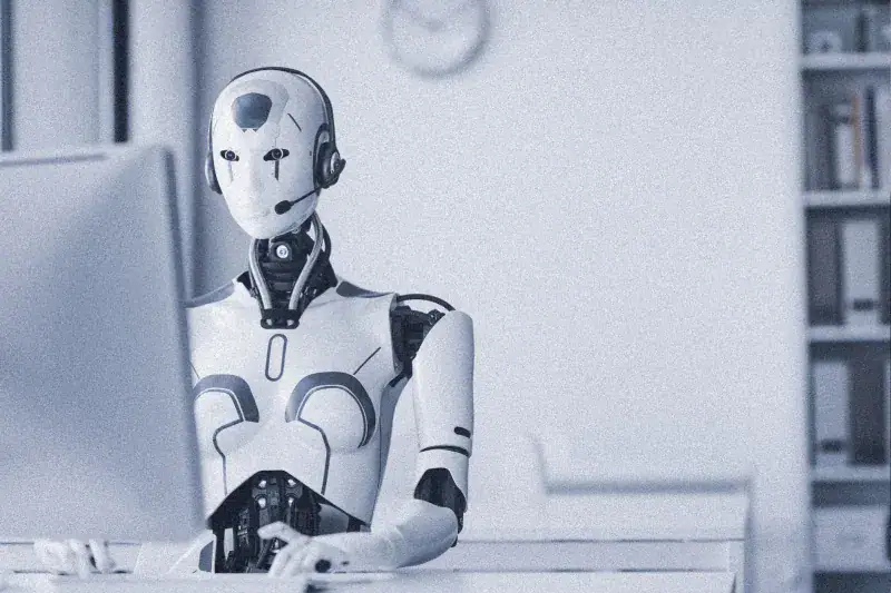 Robot working on computer in office