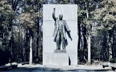 Steinfigur im Park mit erhobenem Arm